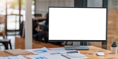 close-up-view-simple-workspace-with-open-blank-screen-laptop-frame-notebook-white-table-with-blurred-office-room-background